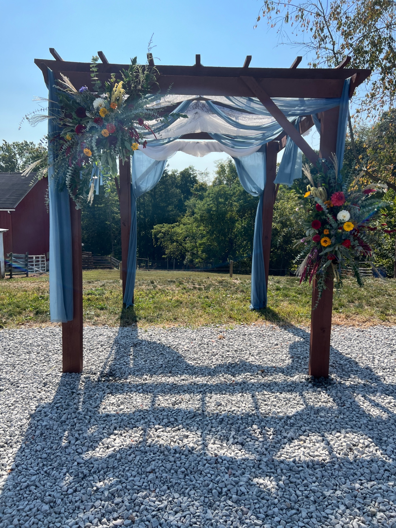 Wedding archway with wildflower florals and blue draping