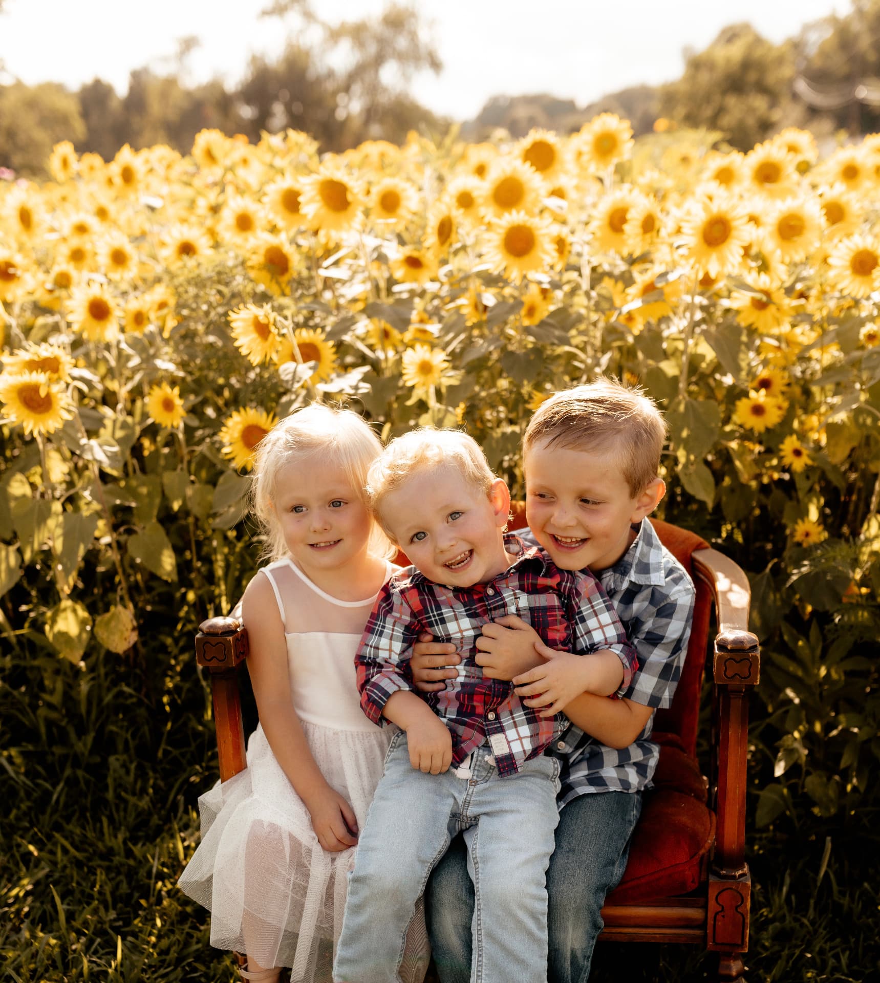 Three children photographed in the sunflower field at Hidden JEM Farm