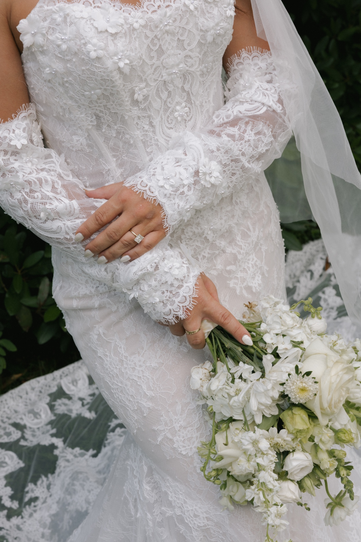 Bride's white bouquet detail with lace dress